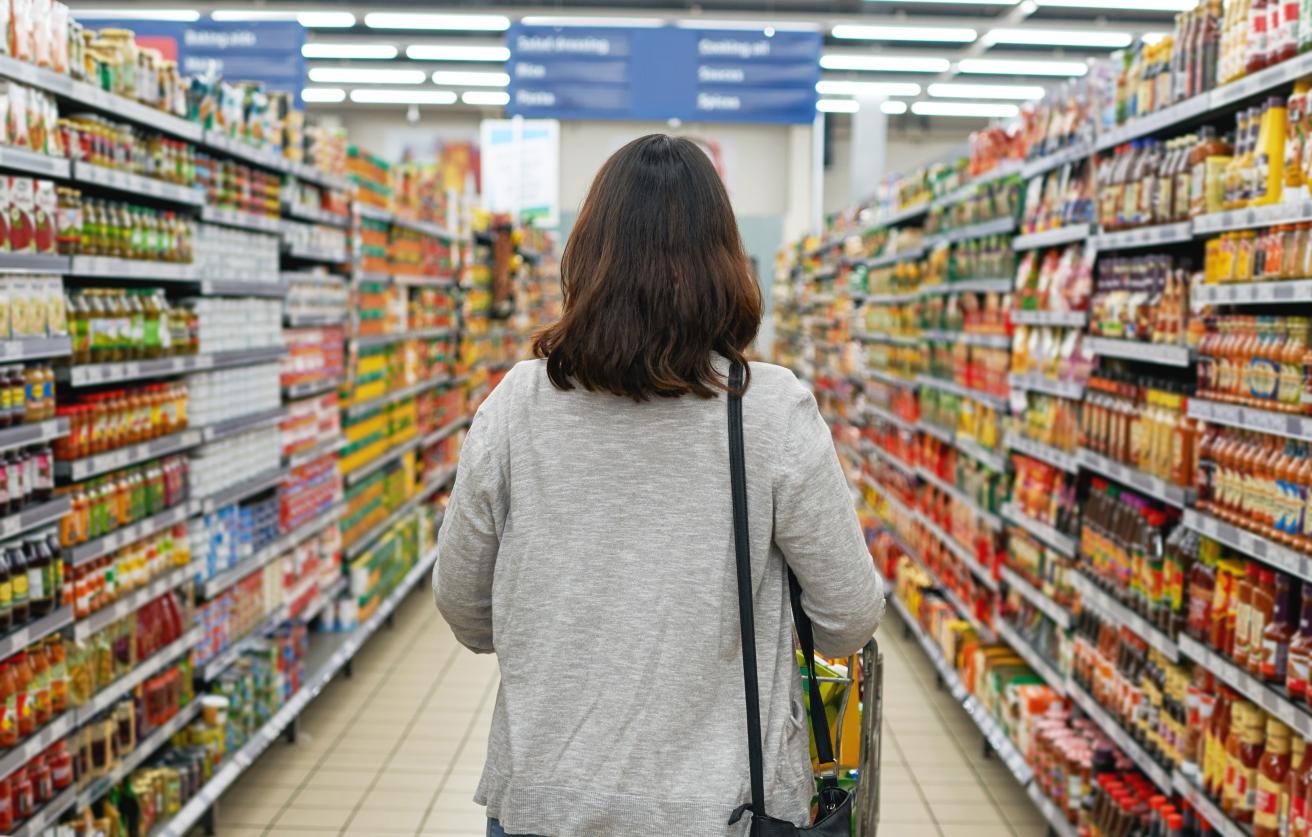 Woman walking down grocery aisle